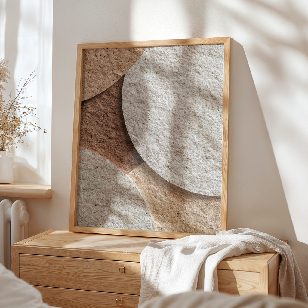 Abstract art piece in a wooden frame on a wall with natural light