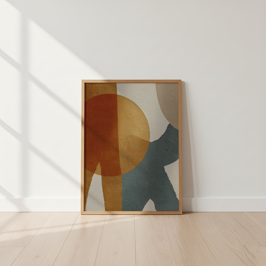 Abstract art print with geometric shapes in a wooden frame on a white wall.