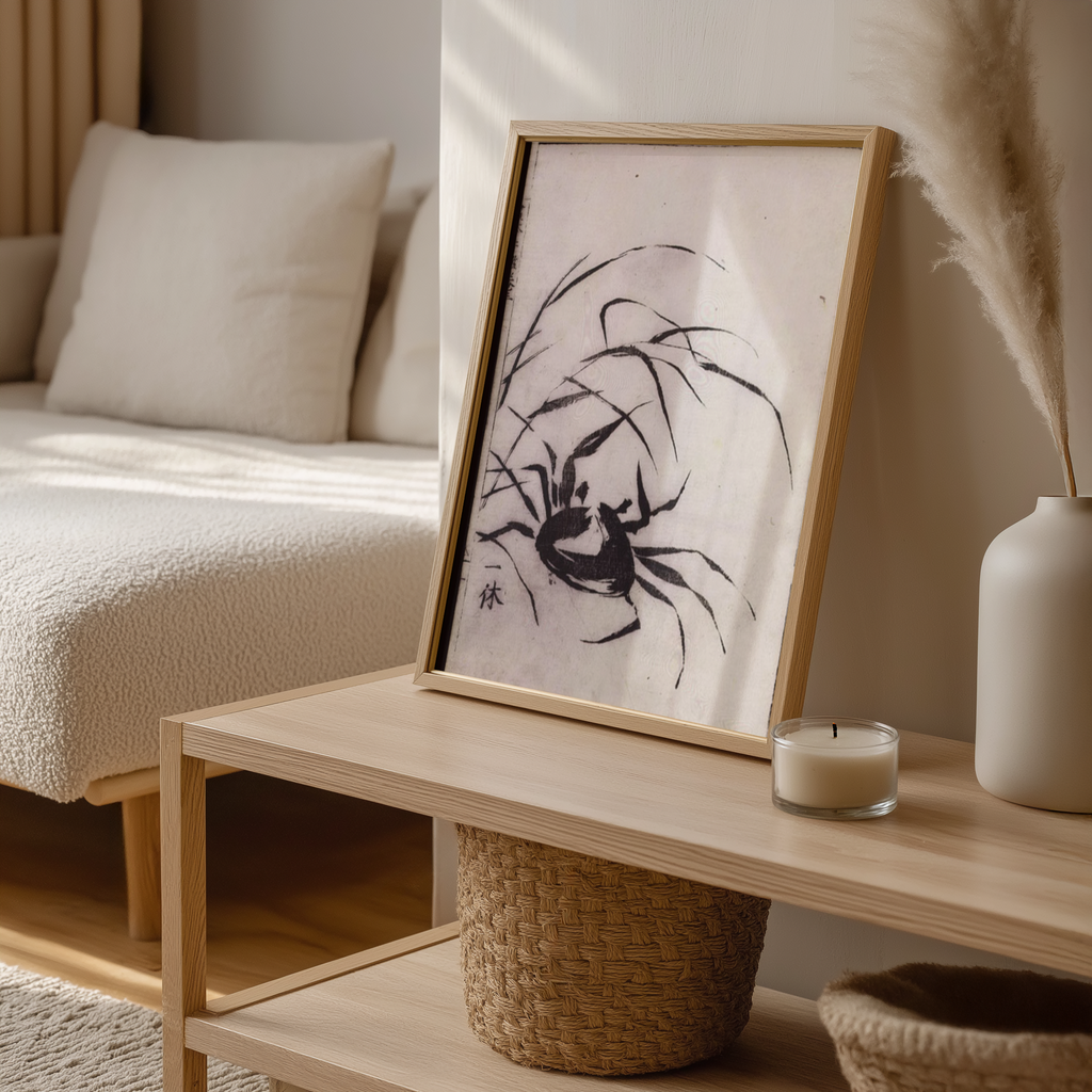 Framed artwork on a wooden coffee table with a candle and decorative items.