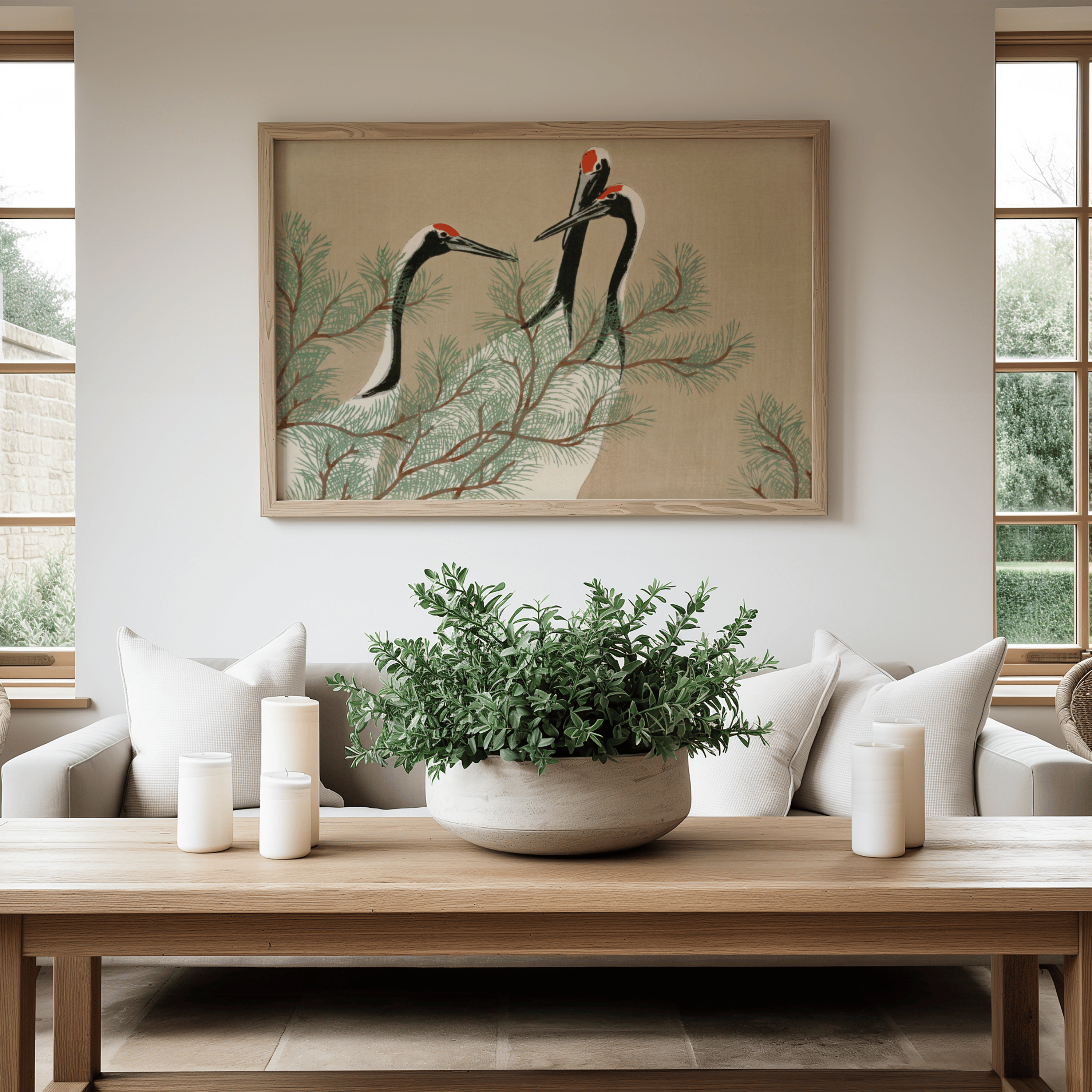 Living room with a framed artwork of cranes on a branch, a potted plant on a coffee table, and a couch.