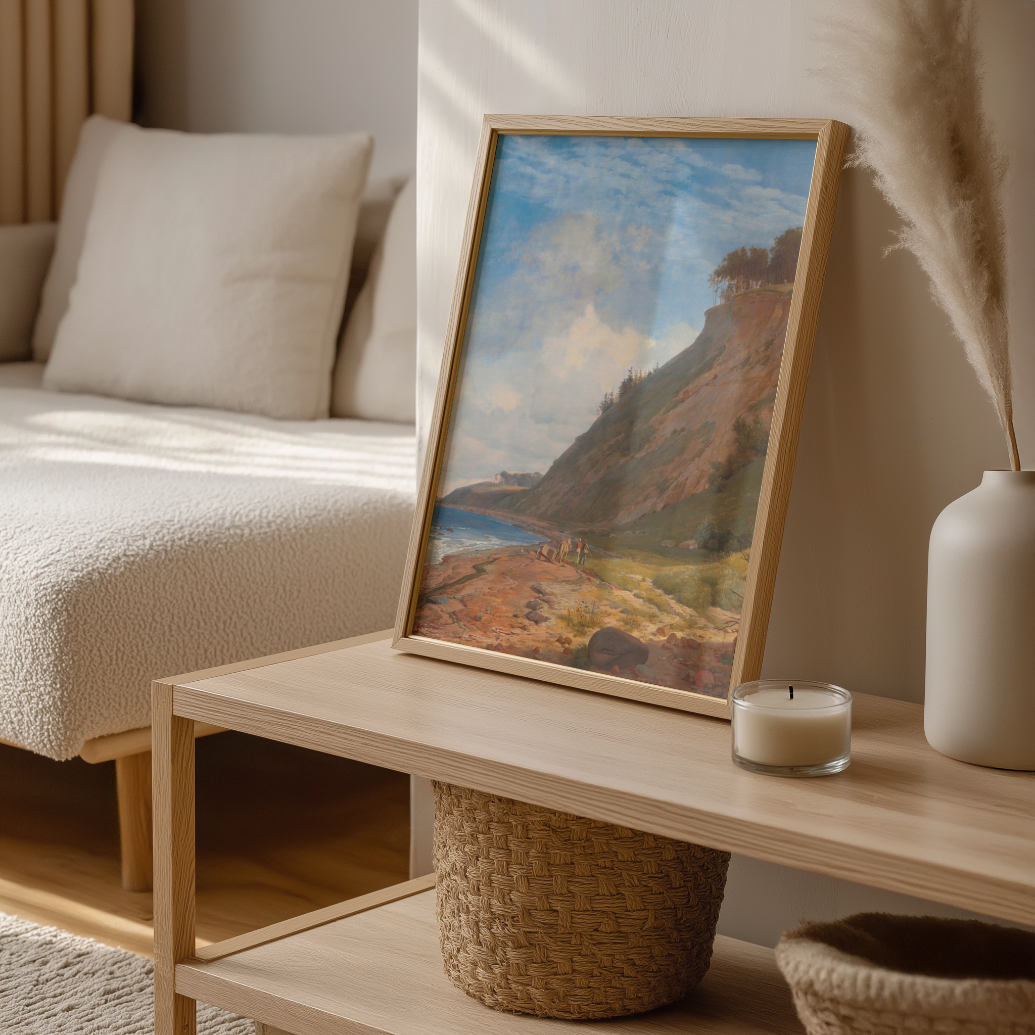 Framed landscape painting on a wooden coffee table with a candle and decorative items.