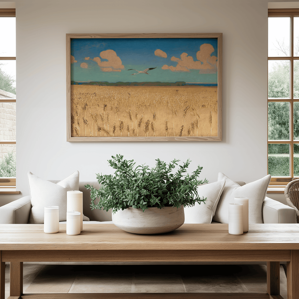 Living room with a painting of a landscape on the wall, a plant on a coffee table, and a couch.
