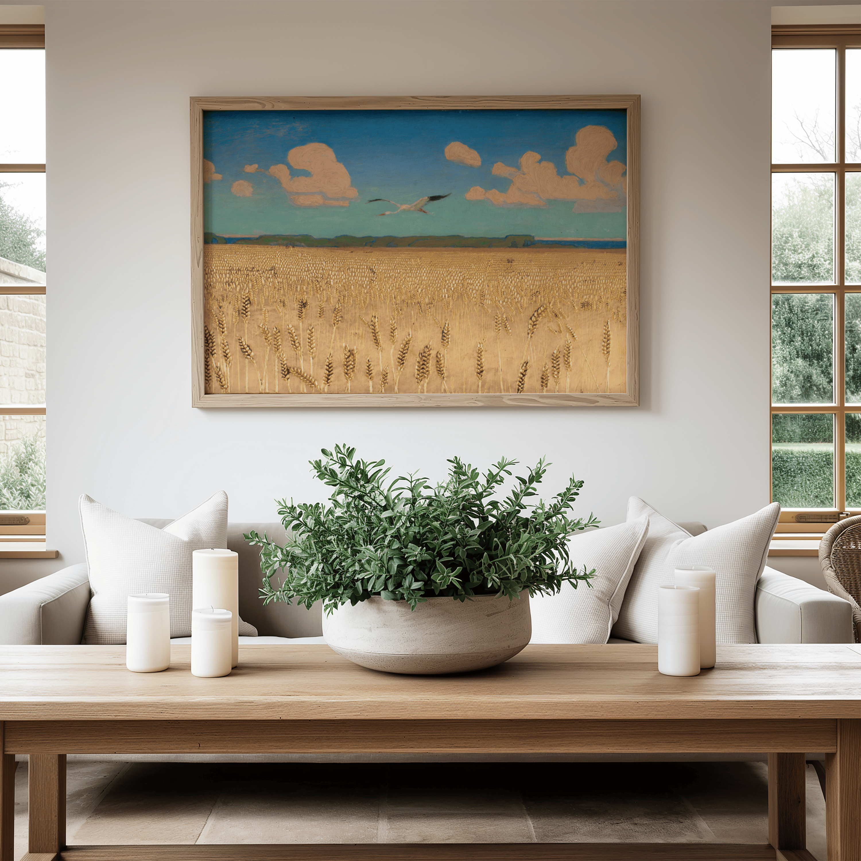 Living room with a painting of a landscape on the wall, a plant on a coffee table, and a couch.