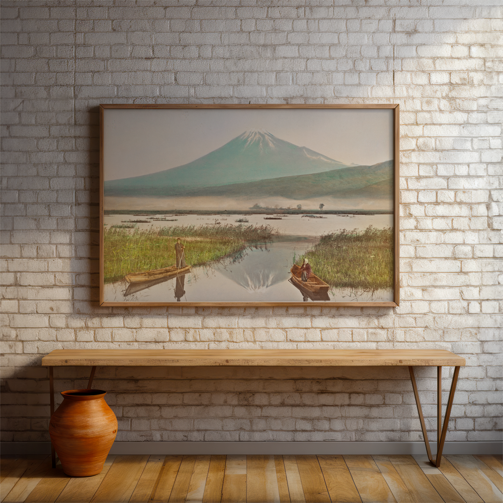 Framed landscape painting of a mountain scene on a brick wall above a wooden bench.