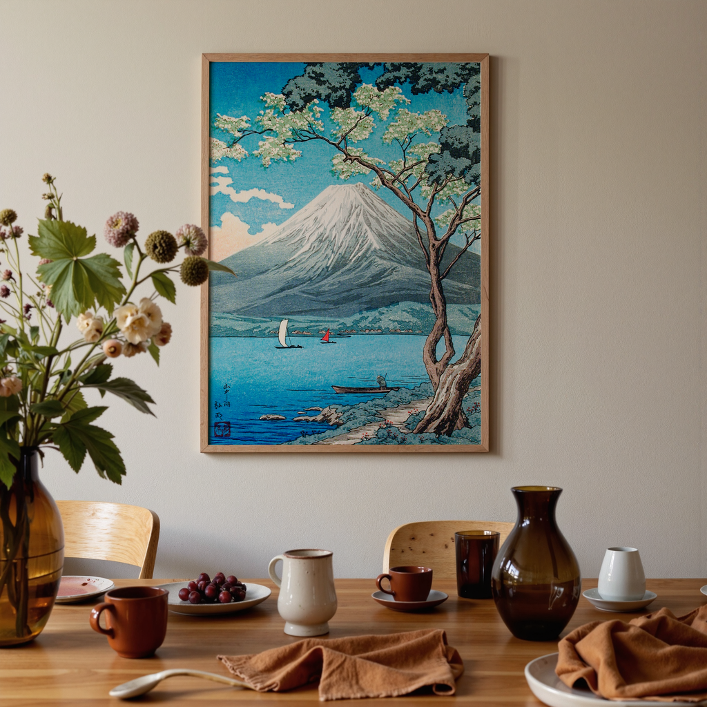 Dining room with a table set for a meal, featuring a framed artwork of a mountain and tree on the wall.