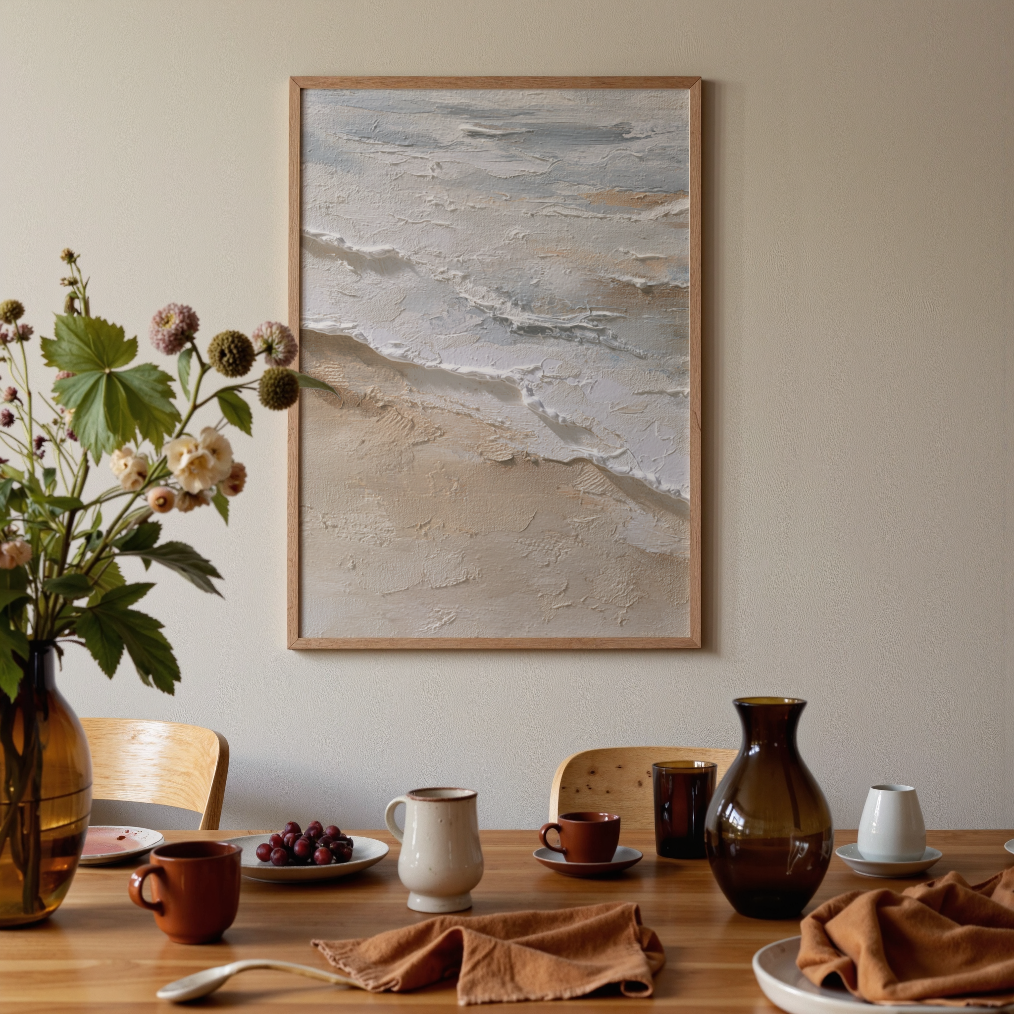Dining room with a table set for a meal, featuring a vase with flowers, plates, and a framed beach scene on the wall.