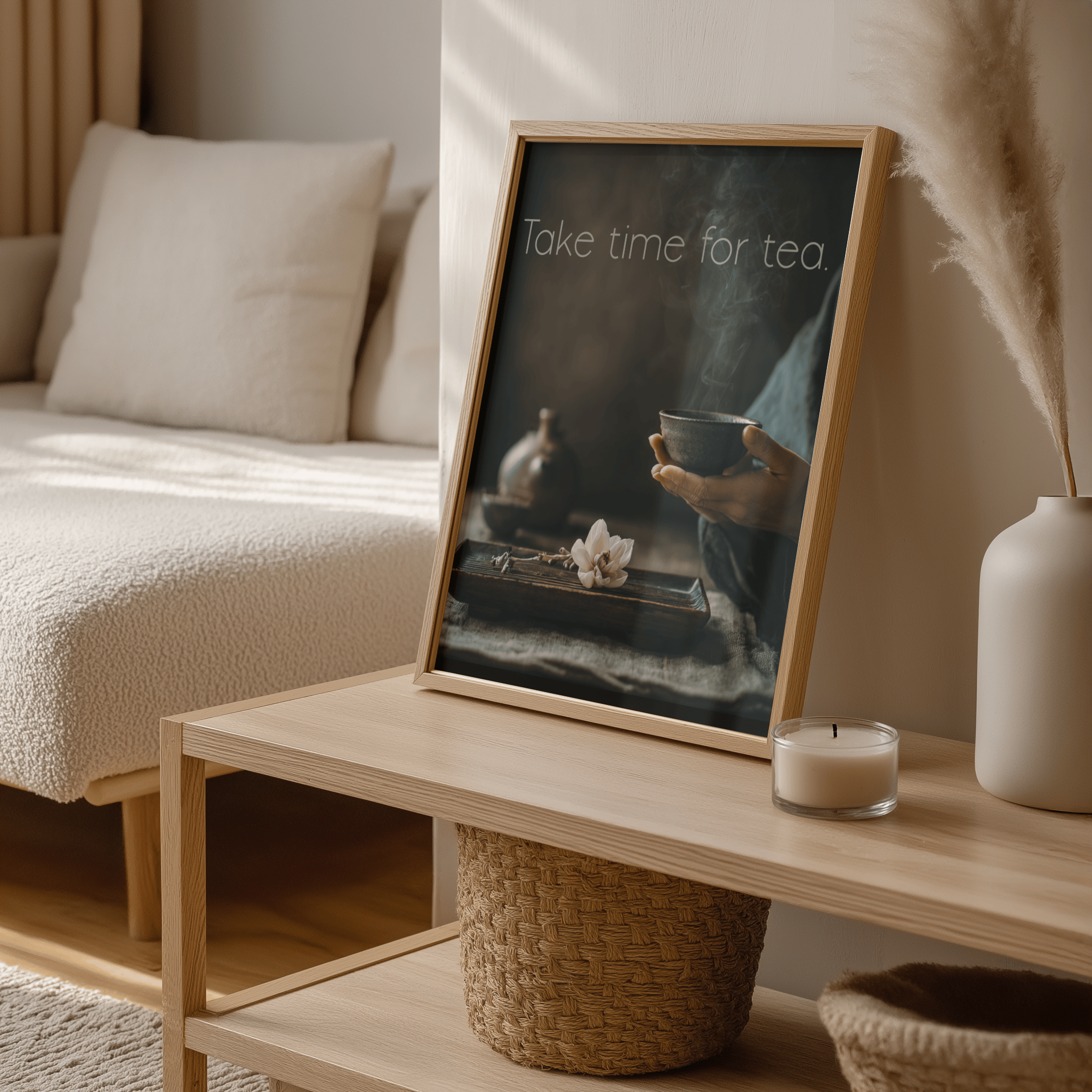 Framed artwork on a wooden table with a candle and decorative items in a cozy living room.