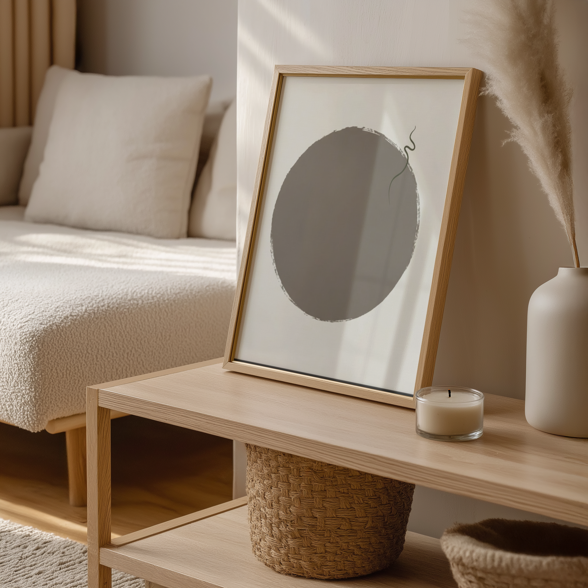 Framed artwork on a wooden coffee table with a candle and decorative items in a cozy living room.