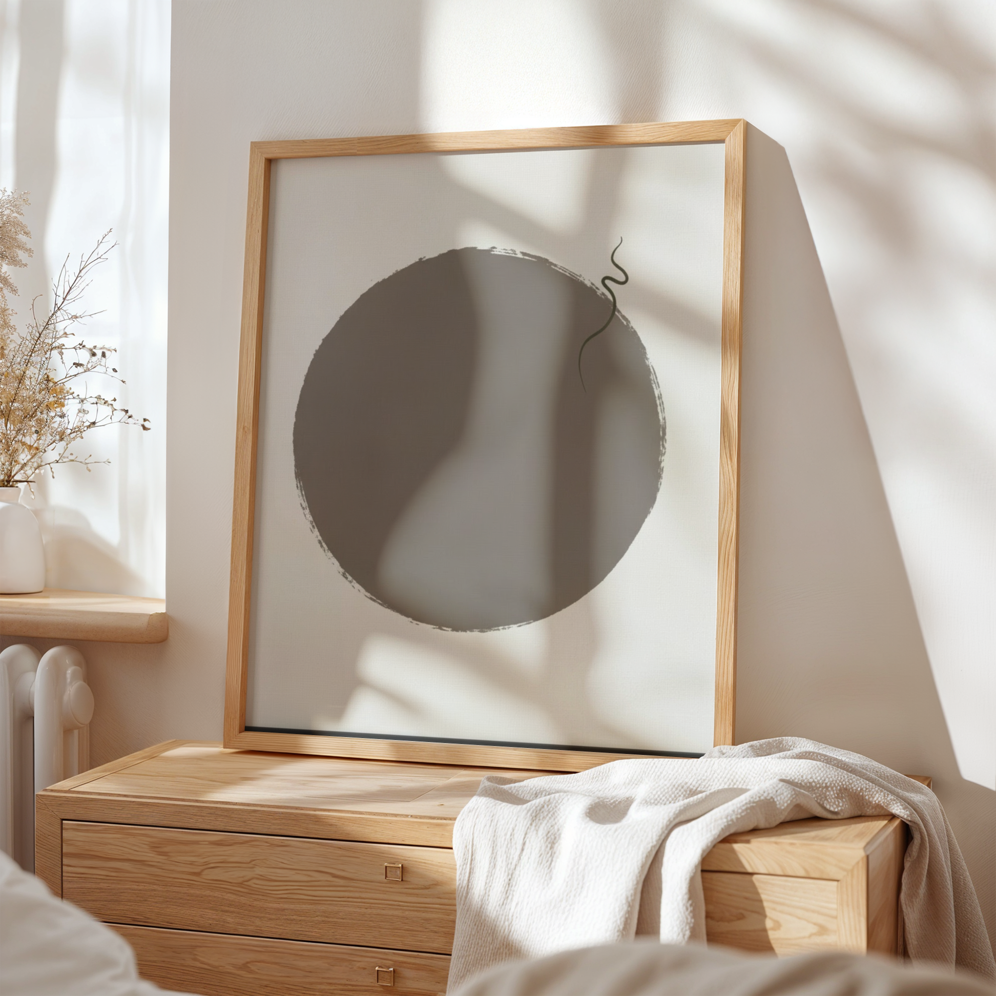 Wooden frame with abstract circular artwork on a wall in a room with natural light.